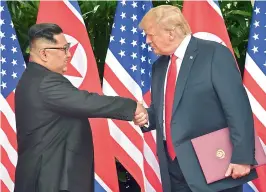  ?? — AFP ?? North Korea leader Kim Jong Un (L) and US President Donald Trump shake hands after their meeting in Singapore on Tuesday.