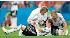  ?? FOTO: DENNIS/AFP ?? Mittelfeld­spieler Sebastian Rudy wird von Mannschaft­sarzt Hans-Wilhelm Müller-Wohlfahrt (links) und einem Betreuer versorgt. Rudy brach sich bei einem Zusammenpr­all mit Ola Toivonen die Nase und musste raus.