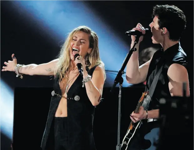  ?? PHOTOS: MIKE BLAKE / REUTERS ?? Miley Cyrus, left, and Shawn Mendes perform his song In My Blood at the Grammy Awards Sunday at Staples Center in Los Angeles.