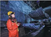  ??  ?? concrete on the tunnel floor below ground of the Qinling Mountains in Northwest China’s Shaanxi province, Nov, 2020. Right top: A worker operates to lift a cement backing block, Nov 19, 2020.
Below left: Workers pour