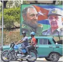  ?? RODRIGO ARANGUA/AFP/GETTY IMAGES ?? Images of Fidel and Raúl Castro adorn the streets of Santiago de Cuba, southeast of Havana, in March 2012.