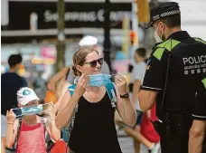  ?? FOTO ČTK/AP ?? Na obličej s ní! Katalánský policista vyzývá na slavném bulváru La Rambla v centru Barcelony ženu, aby si nasadila roušku.