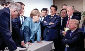  ?? ASSOCIATED PRESS ?? German Chancellor Angela Merkel, center, speaks with U.S. President Donald Trump during the G7 Leaders Summit in Quebec on Saturday.
