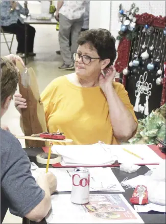  ?? Katie West • Times-Herald ?? Marlene Gwathney looks over entry informatio­n at the St. Francis County Fair Exhibit Hall. Gwathney was one of many volunteers accepting entries this morning in numerous categories that were being judged today. The SFC Fair is continuing through Saturday at the Wiley T. Jones Fairground­s.