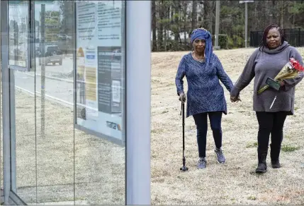  ?? BEN GRAY FOR THE AJC ?? Exie Evans (left) and Marilyn Walton visit the MARTA bus stop near Riverdale and Poplar Springs roads in Clayton County where their relative, Timothy William Crowley, is thought to have died from cold exposure in January. An autopsy on Crowley is not yet completed.