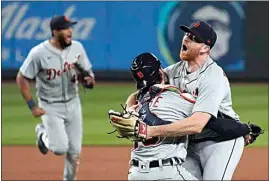  ?? TED S. WARREN / AP ?? Tigers starting pitcher Spencer Turnbull, right, hugs catcher Eric Haase as teammates rush in after Turnbull threw a no-hitter after Tuesday night’s game against the Mariners in Seattle. The Tigers won 5-0.