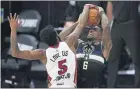  ?? MARK J. TERRILL — THE ASSOCIATED PRESS ?? Derrick Jones Jr. (5), blocks a shot by Milwaukee’s Eric Bledsoe during their playoff game Wednesday.