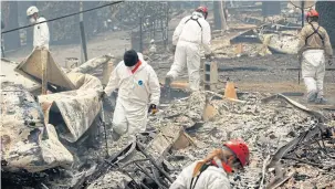  ??  ?? Search and rescue workers search for human remains at a trailer park burned out from the Camp Fire in Paradise, California.