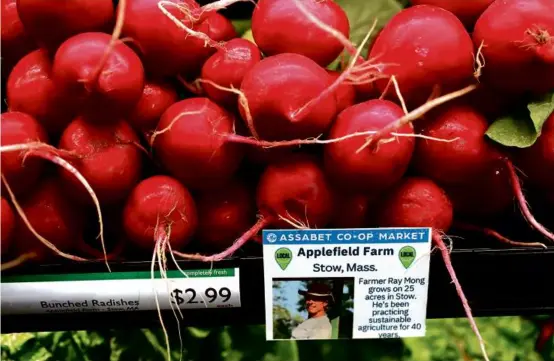  ?? PHOTOS BY SUZANNE KREITER/GLOBE STAFF ?? Radishes grown at Applefield Farm in Stow on sale at the Assabet Co-op Market, which opened late last month in Maynard.