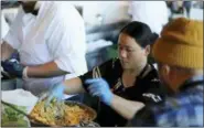  ?? LORIN ELENI GILL — THE ASSOCIATED PRESS ?? In this photo taken Pa Wah, a refugee from Myanmar, mixes shrimp in a turmeric tempura batter at the Hog Island Oyster Co. restaurant in San Francisco during the inaugural Refugee Food Festival.