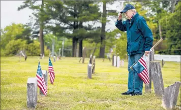  ?? KASSI JACKSON/HARTFORD COURANT ?? Veteran Paul Willis, with American Legion Post 182, salutes a headstone at the final resting place of veterans after planting a flag in honor of them Saturday for Memorial Day at the Granby Cemetery.