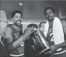  ?? AP PHOTO/FILE ?? Philadelph­ia 76ers Julius Erving, left, and Moses Malone, right, hold the NBA Championsh­ip trophy after defeating the Los Angeles Lakers in Los Angeles, May 31, 1983.