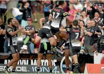  ??  ?? Waqa Blake of the Panthers celebrates with team-mates after scoring against the Warriors.