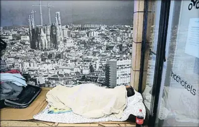  ?? XAVIER CERVERA ?? Una persona duerme junto a la entrada de un hotel, en la Via Laietana de Barcelona