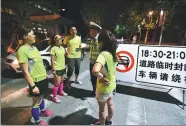  ?? ZHAO JIANPENG / FOR CHINA DAILY ?? Joggers talk to a traffic police officer in Qingdao, Shandong province, on Friday. Traffic police in the city have closed a road near Badaxia Square from 6:30 pm to 9 pm daily to give people a place to exercise.