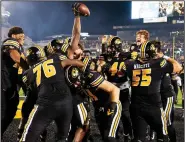  ?? (AP/L.G. Patterson) ?? Missouri players swarm tight end Daniel Parker Jr. after he scored on a two-point conversion Saturday that gave the Tigers a 24-23 overtime victory over Florida in Columbia, Mo.