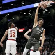  ??  ?? KATHY WILLENS — ASSOCIATED PRESS David Nwaba watches as Nets center Jarrett Allen dunks during the first half March 6 in New York.