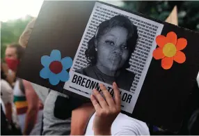  ?? (Jason Connolly/AFP/Getty Images/TNS) ?? A DEMONSTRAT­OR holds a sign with the image of Breonna Taylor, a black woman who was fatally shot by Louisville Metro Police Department officers, during a protest in Denver, Colorado, last week.