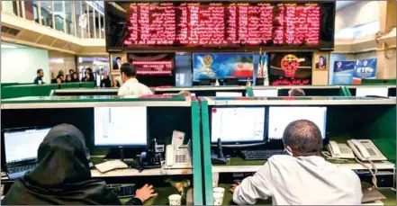  ?? ATTA KENARE/AFP ?? Iranian treaders work at Tehran Stock Exchange on Monday. Its main index, Tedpix, has steadily risen over the last 12 months, accelerati­ng in the most recent quarter to hit a historic high of 248,577 last week – more than twice its level a year ago.