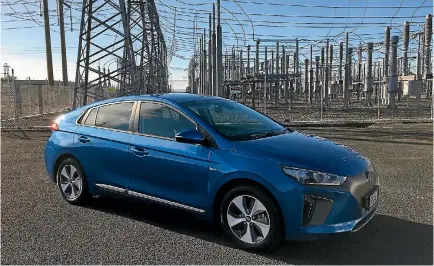  ?? ROB MAETZIG/STUFF ?? A Hyundai Ioniq parked in front of all the transmissi­on lines emerging from a gas-fired power station.