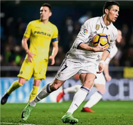  ??  ?? Don’t waste time: Real Madrid striker Cristiano Ronaldo runs with the ball after scoring a goal against Villarreal in the La Liga on Sunday. Real staged a late comeback to win 3-2. — AFP