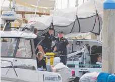  ??  ?? Australian Border Force officers search a vessel escorted by authoritie­s to Southport Yacht Club yesterday.