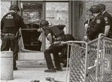  ?? Lola Gomez / Associated Press ?? Austin Police Department check the broken door of Target after protesters forcibly entered the store during a rally decrying the death of George Floyd. Three people allegedly affiliated with antifa have been charged.