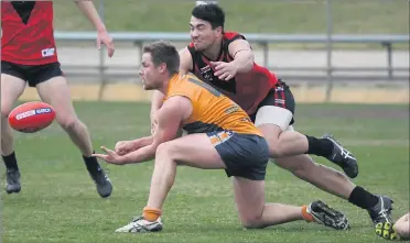  ??  ?? QUICK HANDS: James Wray fires out a handball for Southern Mallee Giants as Stawell’s Jackson Taurau dives into the contest at Stawell’s Central Park. Picture: PAUL CARRACHER