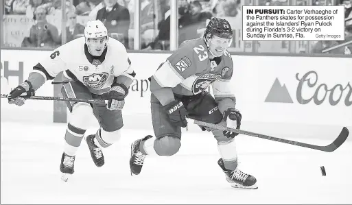  ?? Getty Images ?? IN PURSUIT: Carter Verhaeghe of the Panthers skates for possession against the Islanders’ Ryan Pulock during Florida’s 3-2 victory on Sunday in Sunrise, Fla.