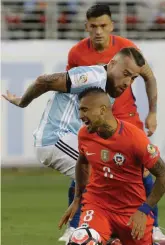  ?? — AP ?? Chile’s Arturo Vidal slips as he and Nicolas Otamendi of Argentina vie for the ball in their match on Monday.