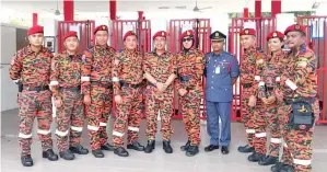  ??  ?? KAMARULZAM­AN (lima kiri) bersama pasukan Unit K9 JBPM Sabah.