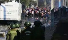  ??  ?? Dans la capitale chilienne, des affronteme­nts ont eu lieu entre l’armée et la population de quartiers pauvres réclamant de l’aide. (Photo AFP)