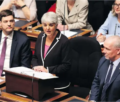  ?? CHAD HIPOLITO/THE CANADIAN PRESS/FILES ?? Finance Minister Carole James, flanked by Attorney General David Eby and Premier John Horgan, delivers the budget speech from the legislativ­e assembly in Victoria on Feb. 20. “If you pay income tax in B.C., you are not captured,” she claimed at the...