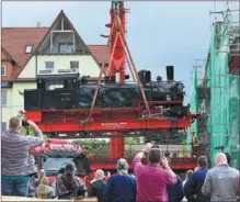  ?? MARTIN SCHUTT / AP ?? A classic Prussian T13 steam locomotive is lifted with a special crane in Meiningen, Germany, on May 10. The walk-in locomotive is set to be the main draw at the Steam Locomotive Experience exhibition at the town’s steam locomotive works.