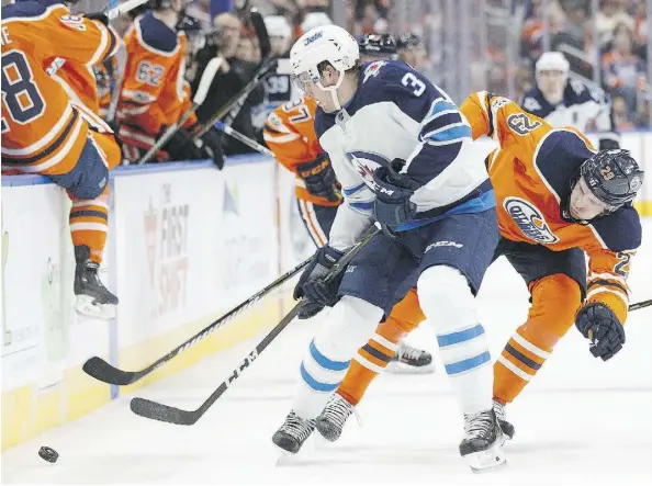  ?? CODIE MCLACHLAN/GETTY IMAGES ?? The Oilers’ Leon Draisaitl, battles against Tucker Poolman of the Winnipeg Jets recently at Rogers Place. Draisaitl suffered an eye injury and possible concussion in the game and will be sidelined for Saturday’s game against Ottawa.