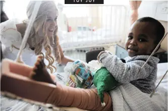  ??  ?? HLELOKUHLE Qubelo gets toys and treats from Belinda Smit, who was visiting the Tygerberg Children’s Hospital. The hospital gave more than 400 kids in the wards gifts sponsored by various organisati­ons. | ARMAND HOUGH African News Agency (ANA)