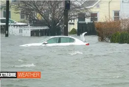  ?? — AP ?? A car along Sea St., is under several feet of water during a storm on Friday in Quincy, Massachuse­ts. A relentless Nor’easter pounded the Atlantic coast with hurricanef­orce winds and sideways- blown rain and snow Friday, flooding streets, grounding...