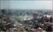  ?? FRANCISCO CABALLERO GOUT VIA AP ?? Shot through a window of the iconic Torre Latina, dust rises over downtown Mexico City during a 7.1 earthquake on Tuesday. Throughout the capital, rescuer workers and residents dug through the rubble of collapsed buildings seeking survivors.