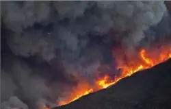  ?? DAVID MCNEW, GETTY IMAGES ?? Strong Santa Ana winds are pushing wildfires across the region, expanding across tens of thousands of acres and destroying hundreds of homes and structures.