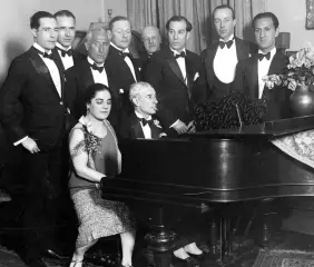  ??  ?? Guests at a 1928 party hosted by Eva Gauthier gather around her as she sits at the piano; George Gershwin is standing on the far right.