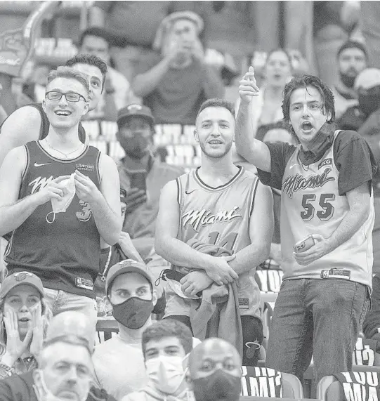  ?? MICHAEL LAUGHLIN/SOUTH FLORIDA SUN SENTINEL ?? Heat fans watch the team enter the court to play the Bucks on Thursday night in the Heat’s season opener.