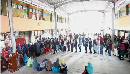  ??  ?? Big turnout: Malaysians queueing up to cast their vote at SK Felda Trolak Utara in Perak.