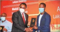  ?? PROVIDED TO CHINA DAILY ?? Simon Nabukwesi (left), Kenya’s principal secretary for university education and research in the Ministry of Education, gives an award to one of the participan­ts in the Huawei contest.