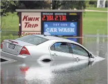  ?? MICHAEL SEARS/ MILWAUKEE JOURNAL SENTINEL ?? A car is submerged at the Kwik Trip at 900 W. Main Street in Watertown. Heavy rains Friday flooded areas of Watertown.