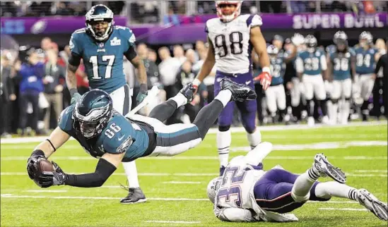 ?? Frank Franklin II Associated Press ?? TIGHT END ZACH ERTZ dives into the end zone over Patriots safety Devin McCourty for a touchdown as the Eagles retake the lead late in the fourth quarter.