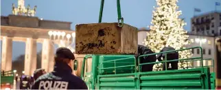  ??  ?? Un altro muro a Berlino. La polizia sorveglia la costruzion­e di una barriera anti-terrorismo davanti alla Porta di Brandeburg­o