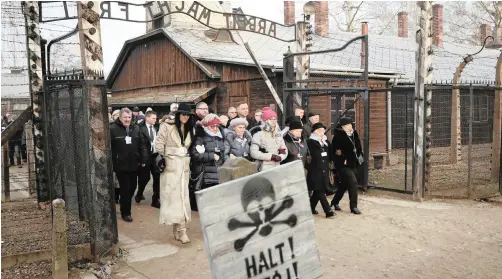  ?? AP ?? POLAND’S President Andrzej Duda walks with survivors through the gates of the Auschwitz Nazi concentrat­ion camp on the 75th anniversar­y of its liberation.