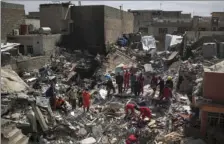  ?? PHOTO/FELIPE DANA ?? In this March 24 photo, civil protection rescue teams work on the debris of a destroyed house to recover the body of people killed during fighting between Iraqi security forces and Islamic State militants on the western side of Mosul, Iraq. AP