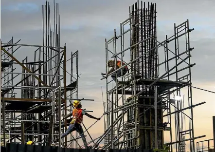  ?? GETTY IMAGES ?? Chinese labourers work on a retail and office complex in Colombo, Sri Lanka. A new report says Chinese workers hired for Belt and Road projects are victims of human traffickin­g and forced labour.