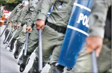  ?? PHA LINA ?? Riot police armed with tear gas launchers get into formation as more than a thousand workers demonstrat­e near the National Assembly to celebrate May Day yesterday in Phnom Penh.